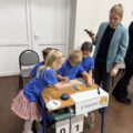 Na zdjęciu przedszkolaki ze Starkowa przy swoim stanowisku wykonują jedną z konkurencji, która polega na ułożeniu z elementów herbu gminy Przemęt.