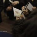 Na fotografii widoczna piosenkarka, która rozdaje ludziom autografy.