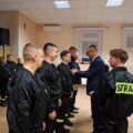 Na zdjęciu widoczny wójt, który przypina odznaki druhom z OSP.