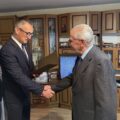 Na fotografii widoczny wójt, który składa jubilatowi gratulacje i odczytuje życzenia z listu gratulacyjnego.