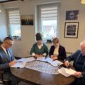Na zdjęciu widać osoby podpisujące umowy.