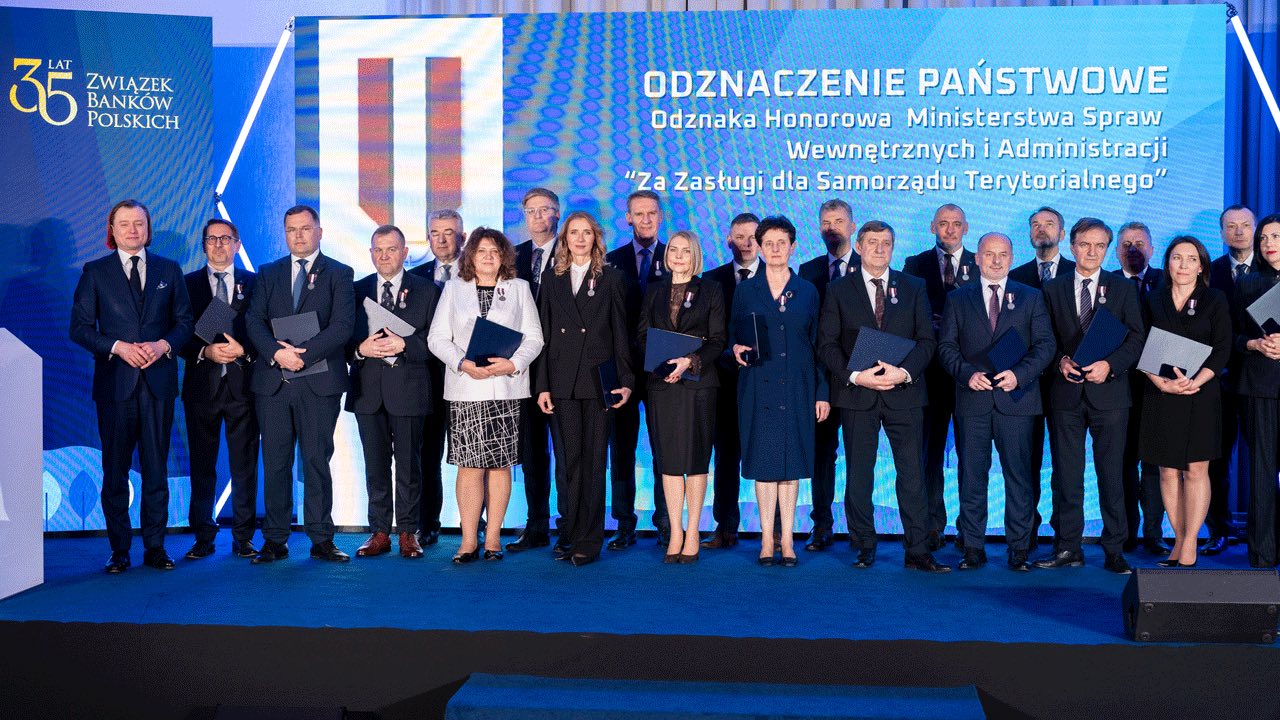 Grupowe zdjęcie osób na scenie.