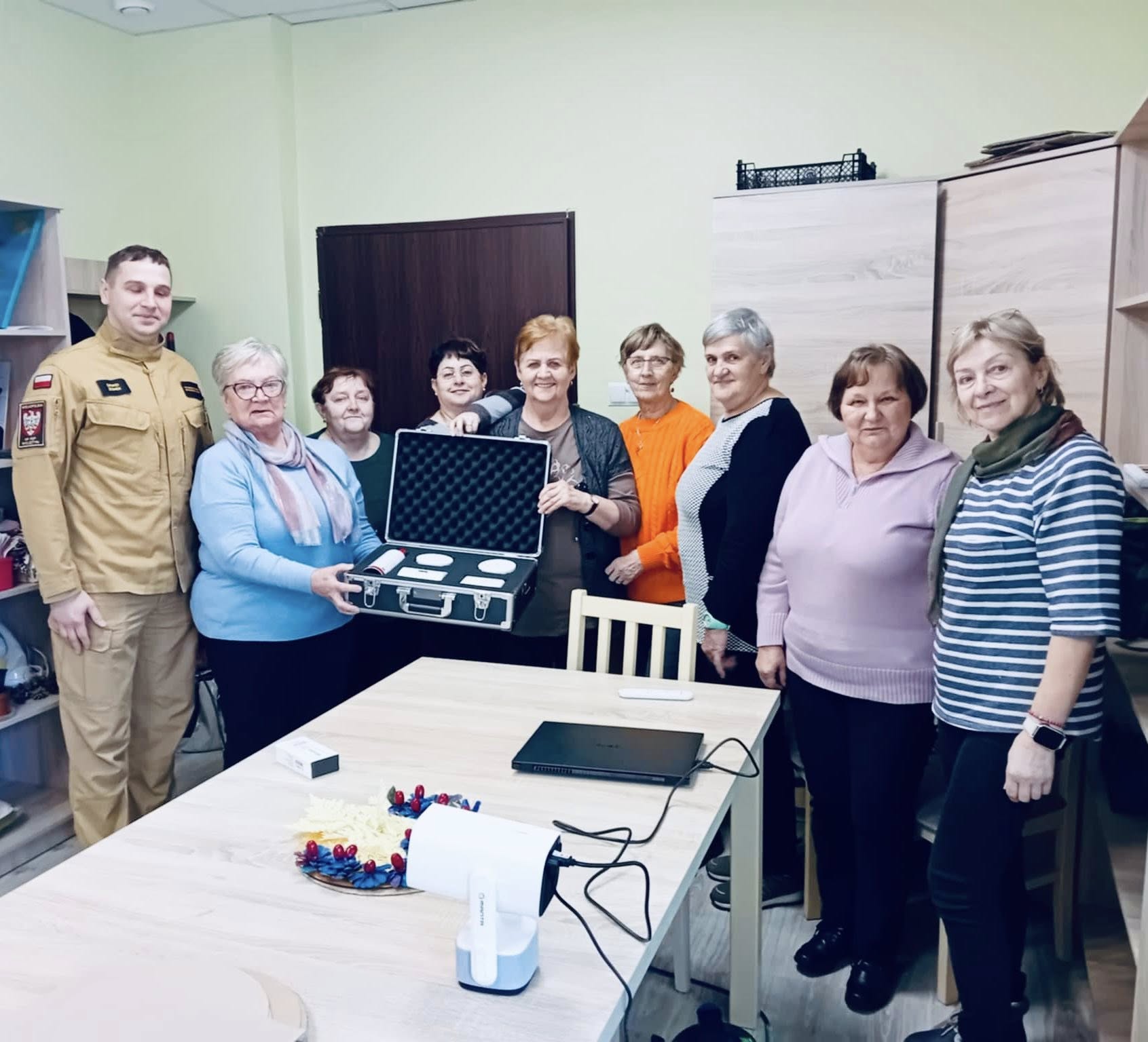 Grupowe zdjęcie seniorów ze strażakami.