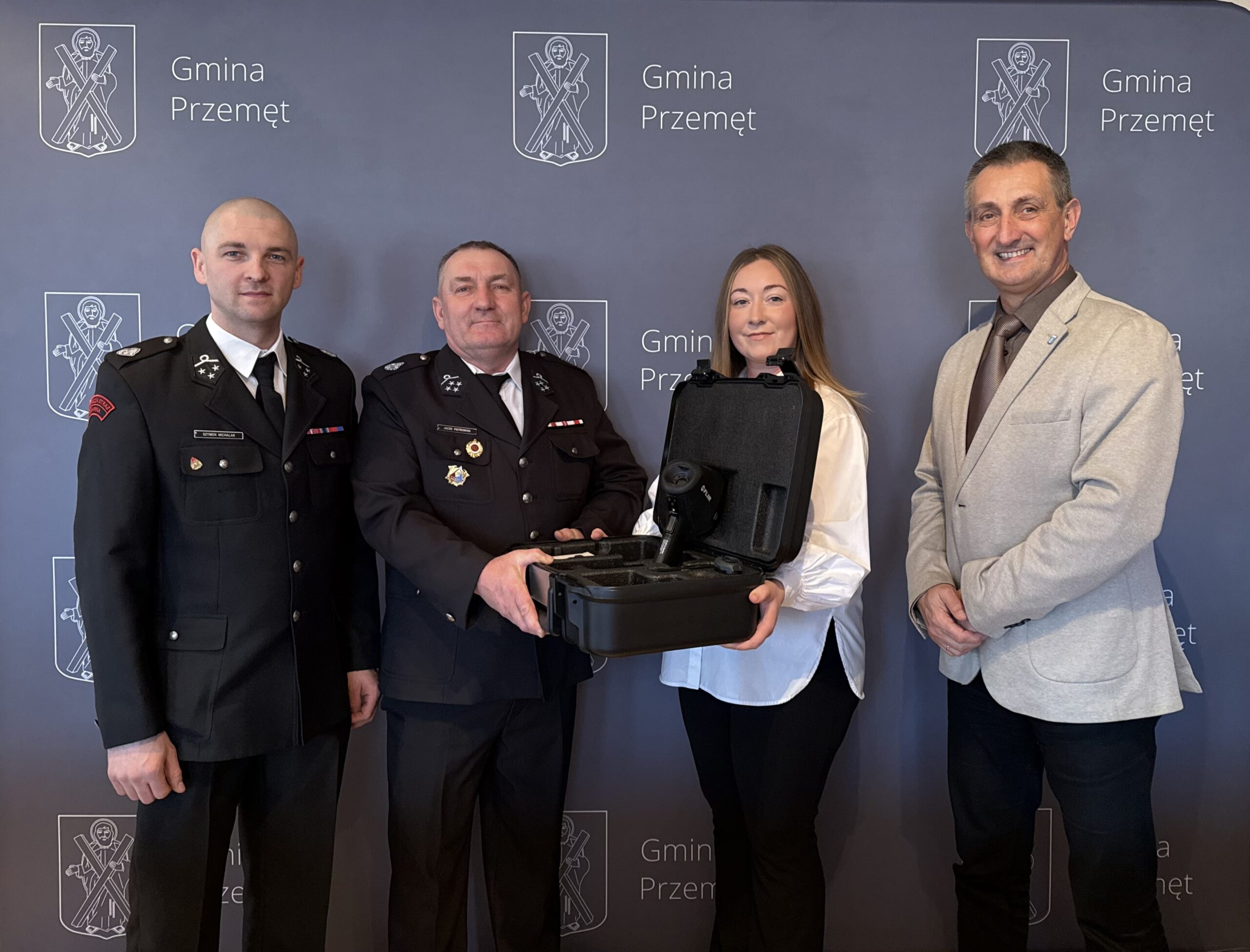 Osoby obecne podczas spotkania pozują z nowym urządzeniem na tle ścianki "Gmina Przemęt".