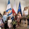 Na zdjęciu widoczne dzieci, które stoją z przystrojonymi gałązkami i koszyczkami.