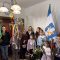 Na zdjęciu widoczne dzieci, które stoją z przystrojonymi gałązkami i koszyczkami.