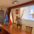 Na fotografii widoczna kobieta, która omawia prezentację wyświetlaną na projektorze.
