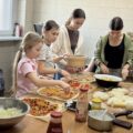 Cztery dziewczynki przygotowują pizzę.
