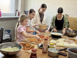 Cztery dziewczynki przygotowują pizzę.