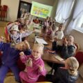 Zdjęcie grupowe. Dzieci przy stołach pozują z nowo wykonaną grą.
