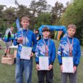 Na zdjęciu trójka zawodników klubu pozuje z medalami i dyplomami.
